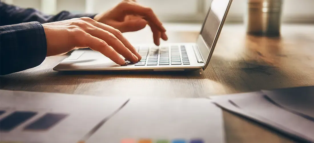 Close up of hands typing on a laptop